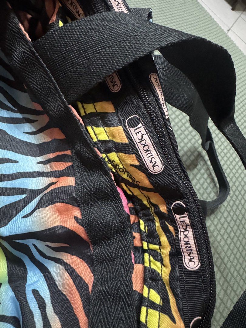 LeSportsac Rainbow Zebra Messenger Bag (Category: Tote Bags) located in Manila. Submitted by plusCize (Listing ID 1431121726, Image 2). Description: LeSportsac Rainbow Zebra Messenger Bag, a vintage piece featuring a colorful rainbow zebra exterior. .
