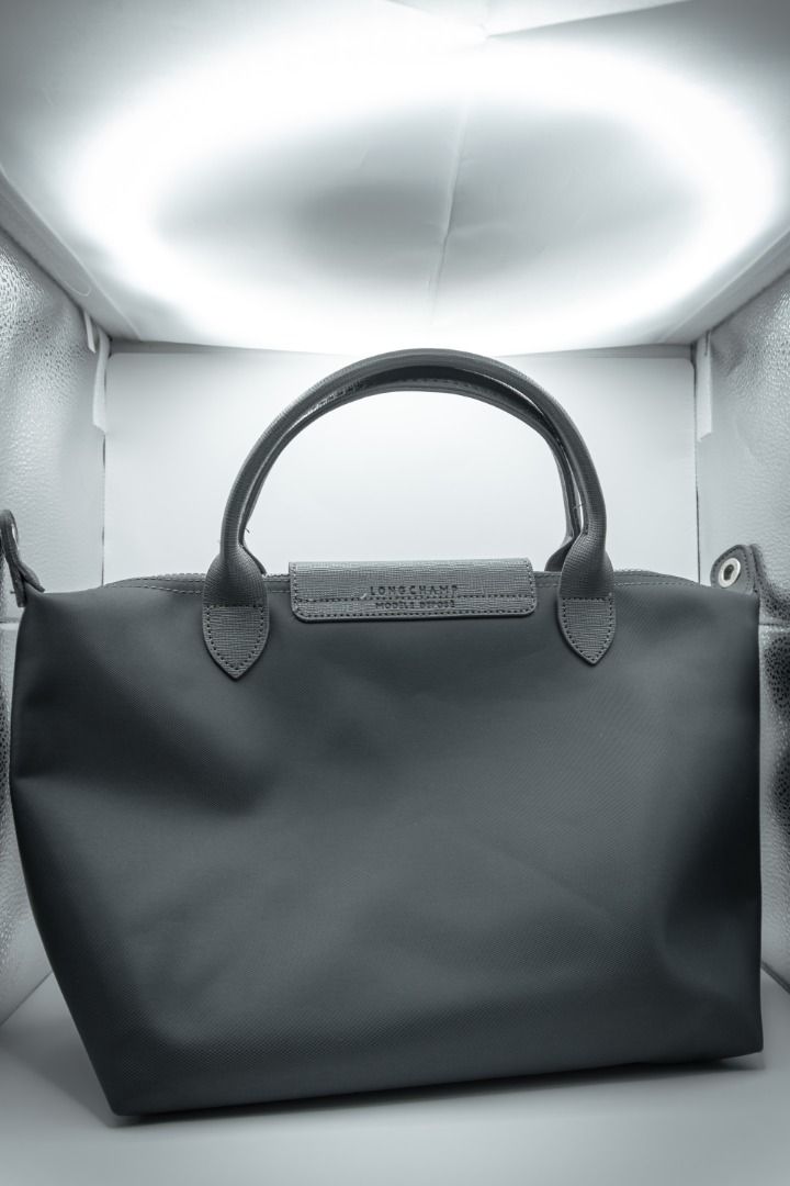 Longchamp Le Pliage Handbag (Category: Luxury Bags & Wallets) located in Silang. Submitted by melstore (Listing ID 1431099188, Image 1). Description: PRE-LOVED ORIGINAL Featuring a top handle and a detachable shoulder strap. The bag has a flap closure with a snap button. The interior is accessible via a zipper. The Longchamp logo is visible on the flap and zipper pull. .