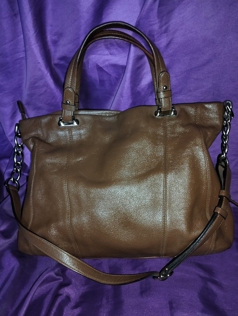 Louis Quatorze Brown Leather Bag (Category: Luxury Bags & Wallets) located in Caloocan City. Submitted by girlshopmcollection (Listing ID 1431121790, Image 2). Description: Handbag set includes a brown leather tote bag and a matching small pouch. The tote bag features a top handle and a detachable shoulder strap with chain accents. The pouch has a zipper closure and a wrist strap. Both items have the Louis Quatorze logo embossed on the front. The