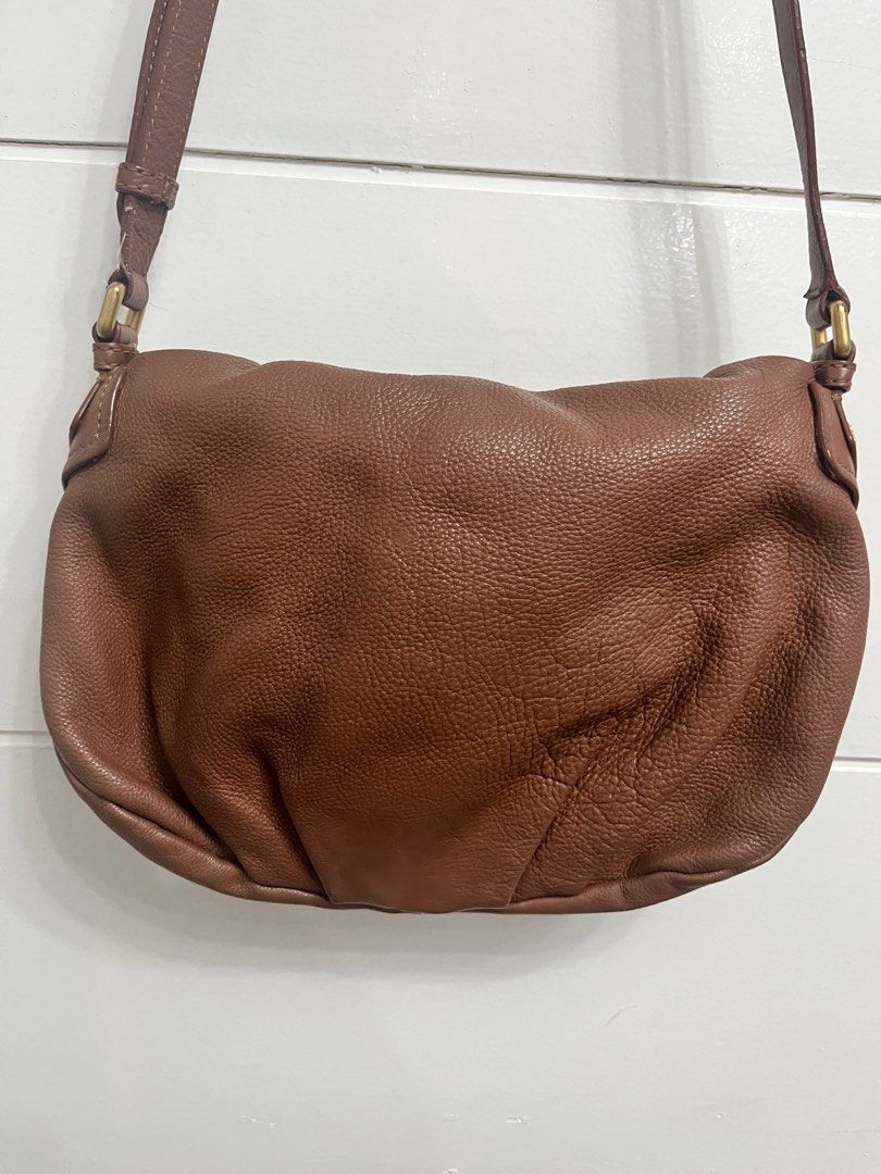 Marc by Marc Jacobs Shoulder Bag (Category: Luxury Bags & Wallets) located in Bulacan. Submitted by spring_cleaning_ (Listing ID 1431073200, Image 2). Description: - Brand: Marc by Marc Jacobs - Color: Brown - Closure: Flap with gold-tone metal plate - Interior: Lined with black and white logo print fabric - Strap: Adjustable shoulder strap - Origin: Made in Indonesia.