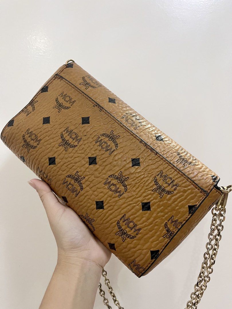 MCM Visetos Chain Wallet Clutch (Category: Luxury Bags & Wallets) located in Cavite. Submitted by vanity_isme (Listing ID 1431022760, Image 3). Description: - Authentic MCM Visetos chain wallet clutch - Iconic MCM logo pattern - Gold-tone chain strap - Flap closure with gold-tone clasp - Interior zippered pocket and small compartment - Minor scratch inner flap -Dimensions: 22 x 15.5 x 5.5cm.