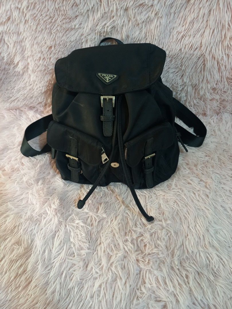 Sale Prada Black Backpack (Category: Luxury Bags & Wallets) located in Valenzuela. Submitted by cc850906 (Listing ID 1431177643, Image 2). Description: Black Prada backpack with multiple compartments and adjustable straps. Features a front flap with a buckle closure and the Prada logo. Includes side pockets with buckle details. The backpack has a drawstring closure and a top handle..