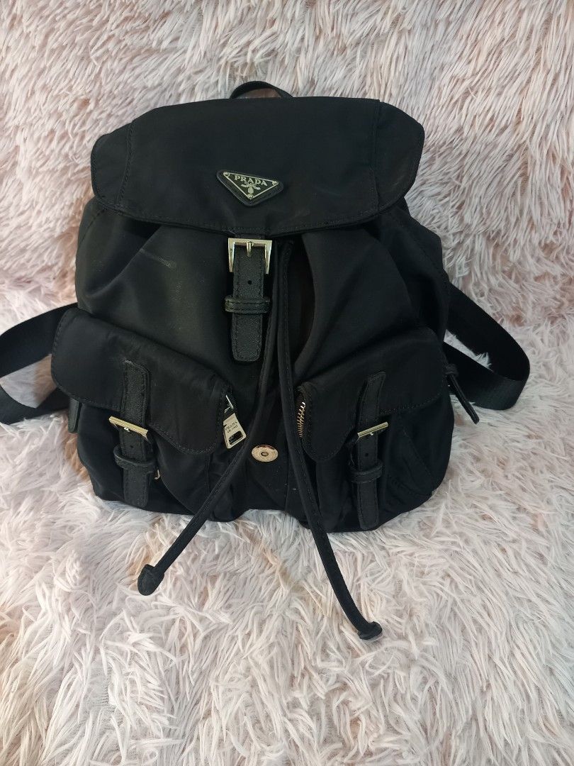 Sale Prada Black Backpack (Category: Luxury Bags & Wallets) located in Valenzuela. Submitted by cc850906 (Listing ID 1431177643, Image 1). Description: Black Prada backpack with multiple compartments and adjustable straps. Features a front flap with a buckle closure and the Prada logo. Includes side pockets with buckle details. The backpack has a drawstring closure and a top handle..
