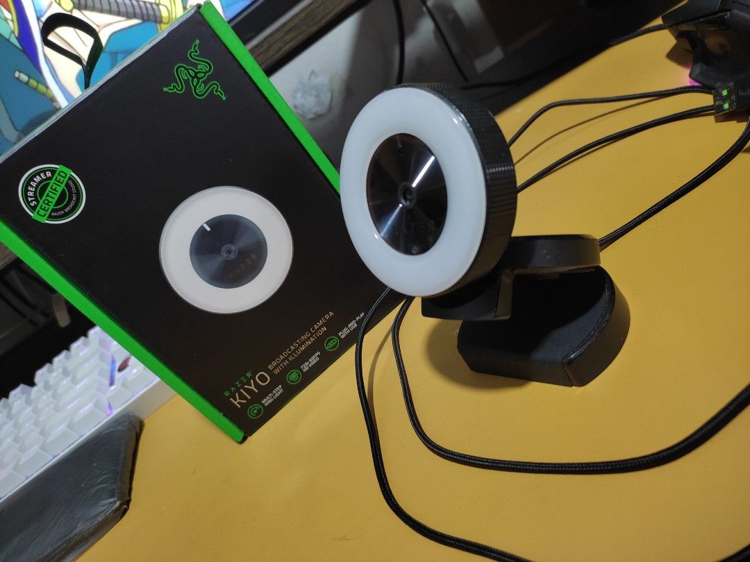 Razer Kiyo Streaming Webcam (Category: Webcams) located in Manila. Submitted by dos9quatro (Listing ID 1431029486, Image 2). Description: rfs: not really used. spring cleaning. product description 👇 price negotiable. Razer Kiyo streaming webcam with built-in ring light. Includes the original box and documentation. The webcam has a sleek black design with a white ring light. The box indicates it is "For Gamers. By Gamers.".