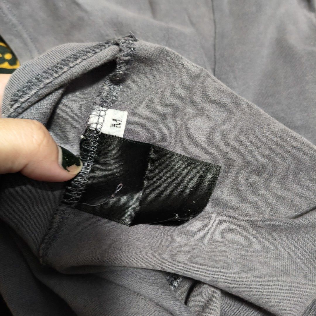 Saint Laurent Paris Grey T-shirt (Category: Shirts) located in Manila. Submitted by stuff_finder (Listing ID 1431049569, Image 3). Description: Saint Laurent Paris grey t-shirt. Features the brand's logo on the front and the brand name on the back. The shirt has a crew neck and short sleeves. The size tag is visible. There are some stains on the front of the shirt. unisex.