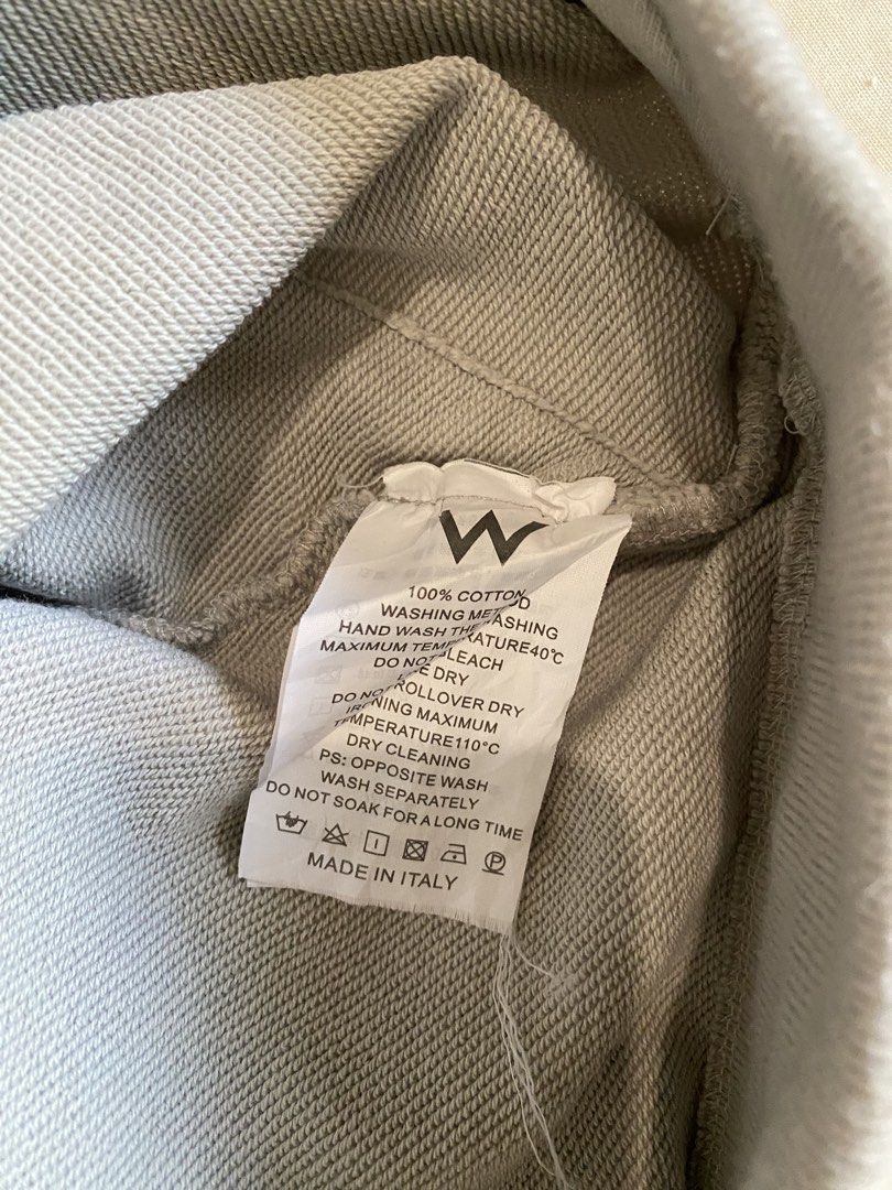 SMFK Infiniti Shorts DS002W (Category: Shorts) located in Kalayaan. Submitted by kolaso29 (Listing ID 1431007830, Image 2). Description: Authentic SMFK Infiniti Shorts. Made in Italy. Features a drawstring waist and the SMFK logo. The shorts are a light grey color. The tag indicates the shorts are size S and made of 100% cotton. Washing instructions include hand wash, do not tumble dry, and dry cleaning..