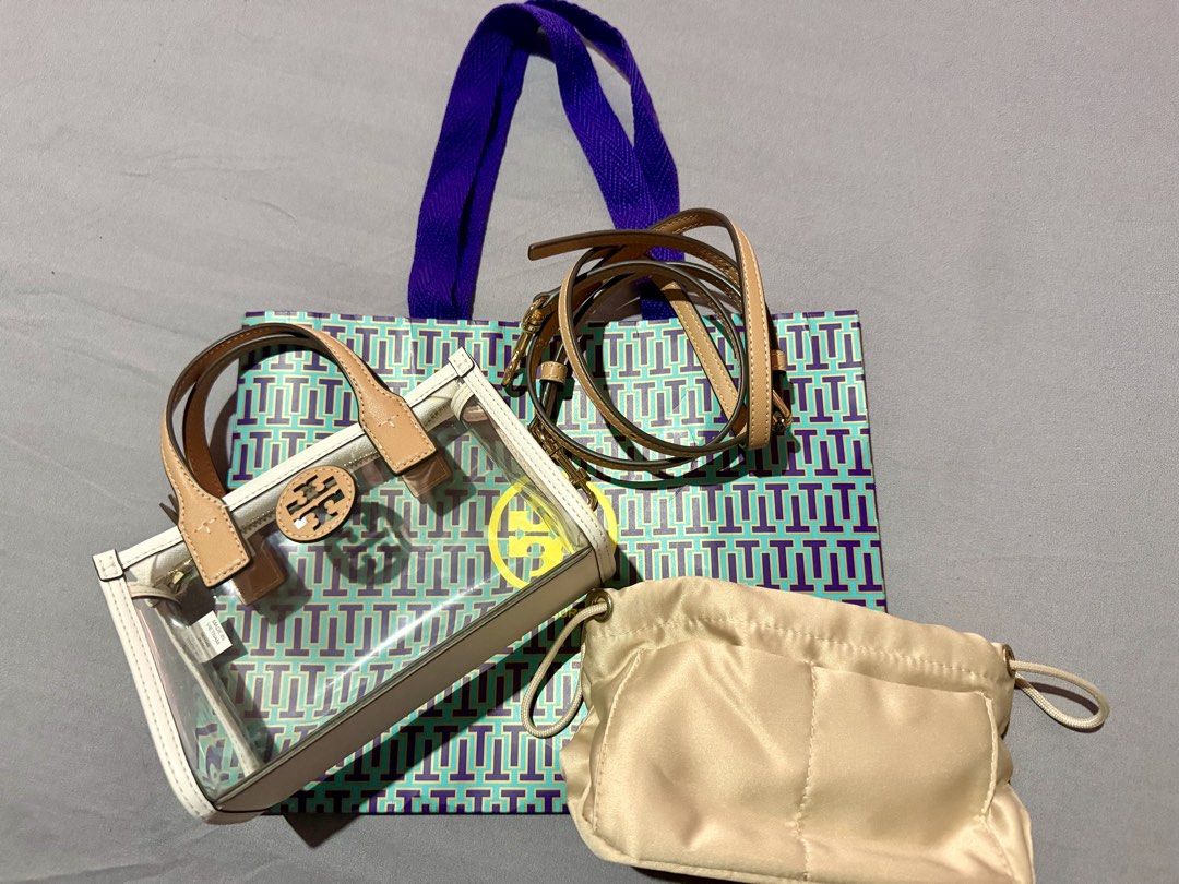 Tory Burch Mini Ella (Category: Luxury Bags & Wallets) located in Pasay City. Submitted by jennchua19 (Listing ID 1431035465, Image 2). Description: Description -Authentic Tory Burch Mini Ella -white and tan in color -Clear PVC Vinyl - gold Zip closure - adjustable removable cross body strap 23.1” - height 4.8”, length 7.2”, depth 2.8” -with FREE insert pouch (para ndi kita loob) bought from orange app 600 pesos only used once - ndi ko nagagamit 