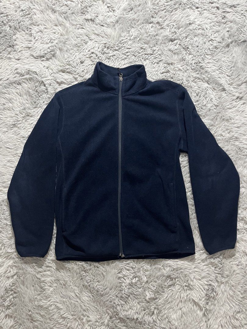 Uniqlo Navy Blue Fleece Jacket (Category: Coats, Jackets and Outerwear) located in Taytay. Submitted by mc_marcy (Listing ID 1431000371, Image 1). Description: Navy blue fleece jacket features a full zip closure and a high collar. The jacket has a simple, classic design, suitable for casual wear. It looks comfortable and warm, perfect for cooler weather..