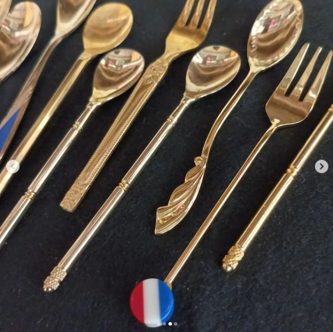 Vintage Gold Spoons and Forks Tea Set (Category: Dinnerware & Cutlery) located in Quezon City. Submitted by mrsincognito (Listing ID 1431178809, Image 2). Description: Elegant set of vintage gold spoons and forks. Includes various spoon sizes and forks with decorative handles. Some spoons have blue enamel detailing. Features a French flag charm. Perfect for adding a touch of vintage charm to your dining experience..