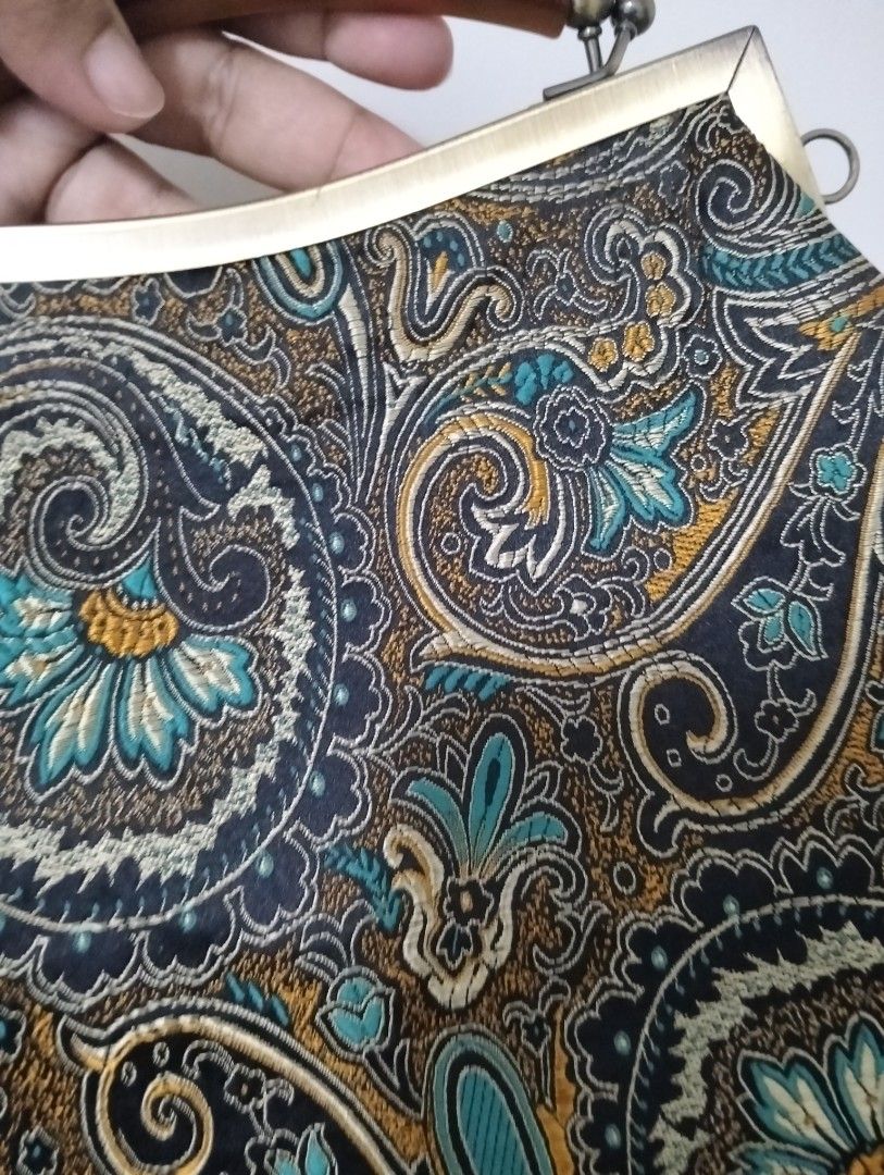 Vintage Paisley Handbag with Chain Strap (Category: Luxury Bags & Wallets) located in Gasan. Submitted by AngeliqueKaye (Listing ID 1420396040, Image 3). Description: - Vintage handbag - Unique paisley pattern (blue, brown, black) - Metal frame - Top handle - Detachable chain strap - Clasp closure - Light-colored interior lining - Small interior pocket - Metal accents.