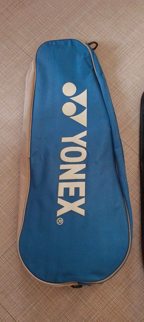 Yonex Badminton Racket Bag (Category: Racket and Ball Sports) located in Quezon City. Submitted by rominaa (Listing ID 1431026115, Image 1). Description: Yonex badminton racket bag. It is blue with a white Yonex logo. The bag has a zipper closure and a handle for carrying. The bag's exterior is blue and beige..