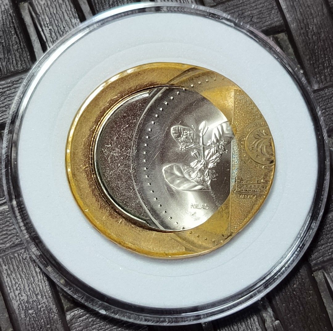 20 Piso Coin "off center error" (Category: Currency) located in Taguig. Submitted by ezekiel103 (Listing ID 1435493678, Image 2). Description: - 20 Piso Coin"off center error" - Encased in a clear protective case - Features a portrait on one side - Plant design on the other side - Gold-colored outer ring - Silver-colored middle section - Copper-colored center 30k nalang.