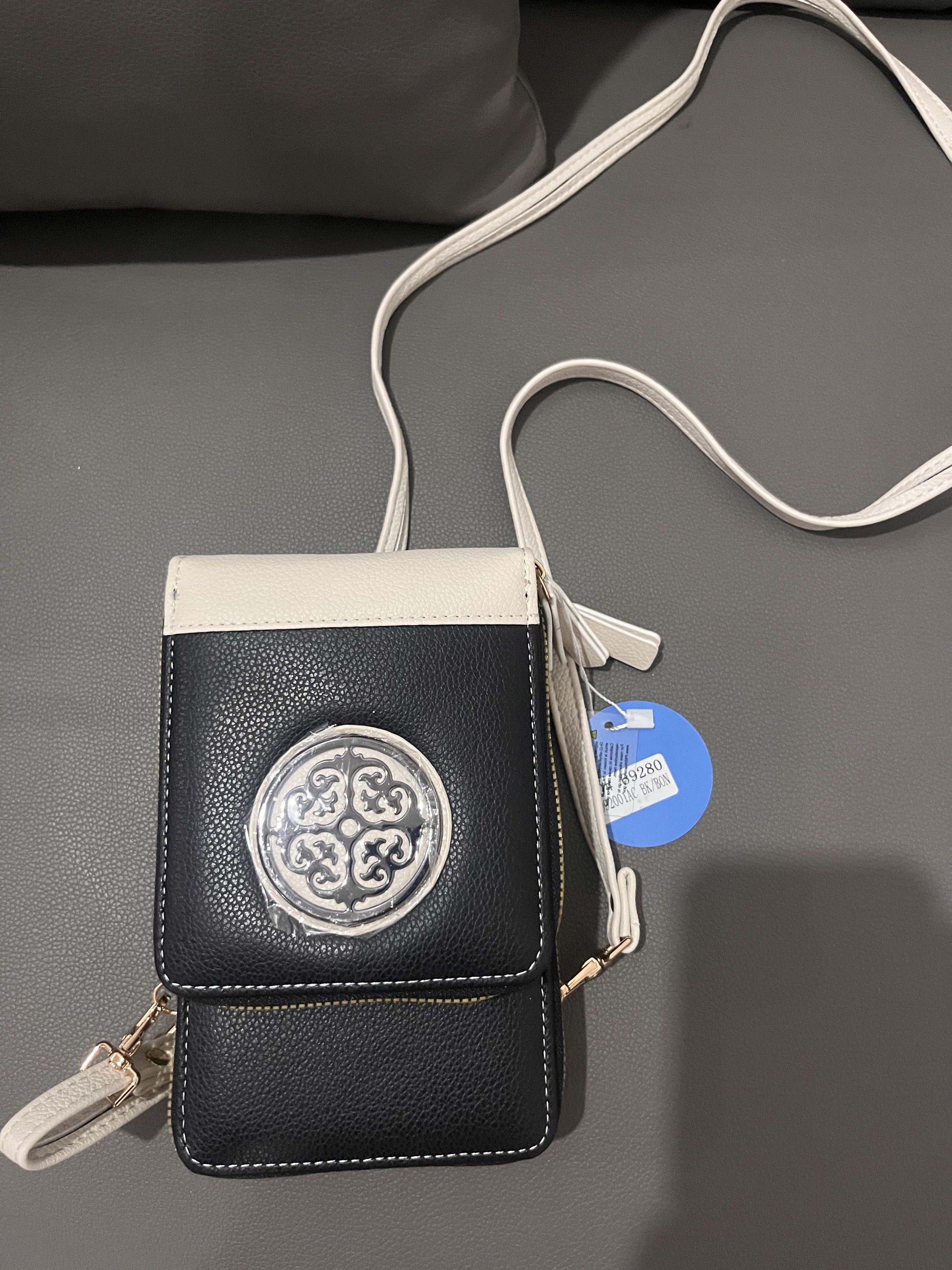Black and White Crossbody Bag (Category: Cross-body Bags) located in Manila. Submitted by summer424 (Listing ID 1435472998, Image 2). Description: - Stylish black and white crossbody bag - Decorative silver emblem - Long white strap included - Features a small wrist strap - Multiple compartments with gold zippers - Brand new with price tag attached.