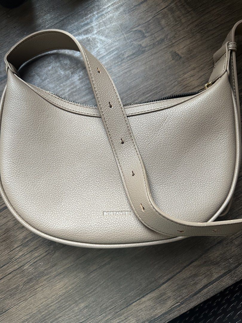 Bostanten Shoulder Bag (Category: Shoulder Bags) located in Quezon City. Submitted by quality.declutters (Listing ID 1435428650, Image 2). Description: - Bostanten shoulder bag - Crescent shape - Neutral color - Zipper closure - Adjustable strap - Main compartment and slip pocket - Textured material - Brand logo visible - No damages - RFS: Decluttering, not using it anymore - MOP: Gcash/Gotyme/BPI.