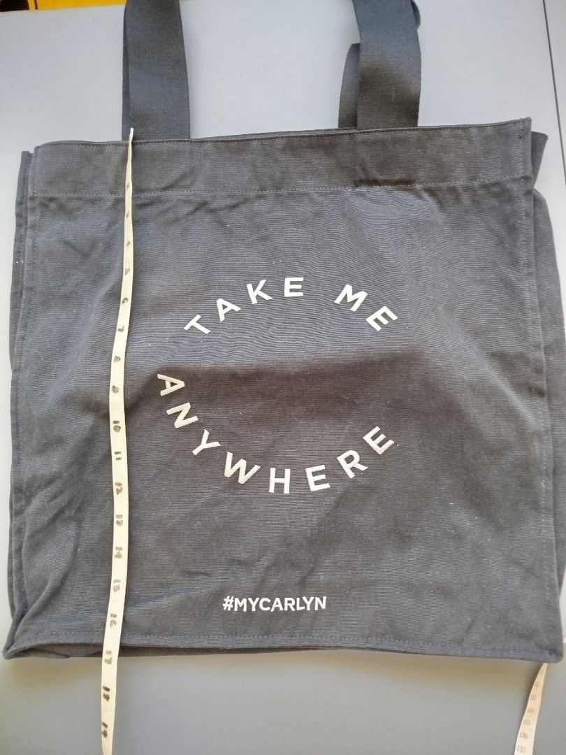 Carlyn Take Me Anywhere Tote Bag (Category: Tote Bags) located in Calamba. Submitted by merrymerida (Listing ID 1435367814, Image 2). Description: - Carlyn Tote Bag with "Take Me Anywhere" design - Color: Dark Gray - Features a zippered interior pocket - Made of durable fabric - Dimensions: Approximately 15" Height x 16" Width - Sturdy handles.