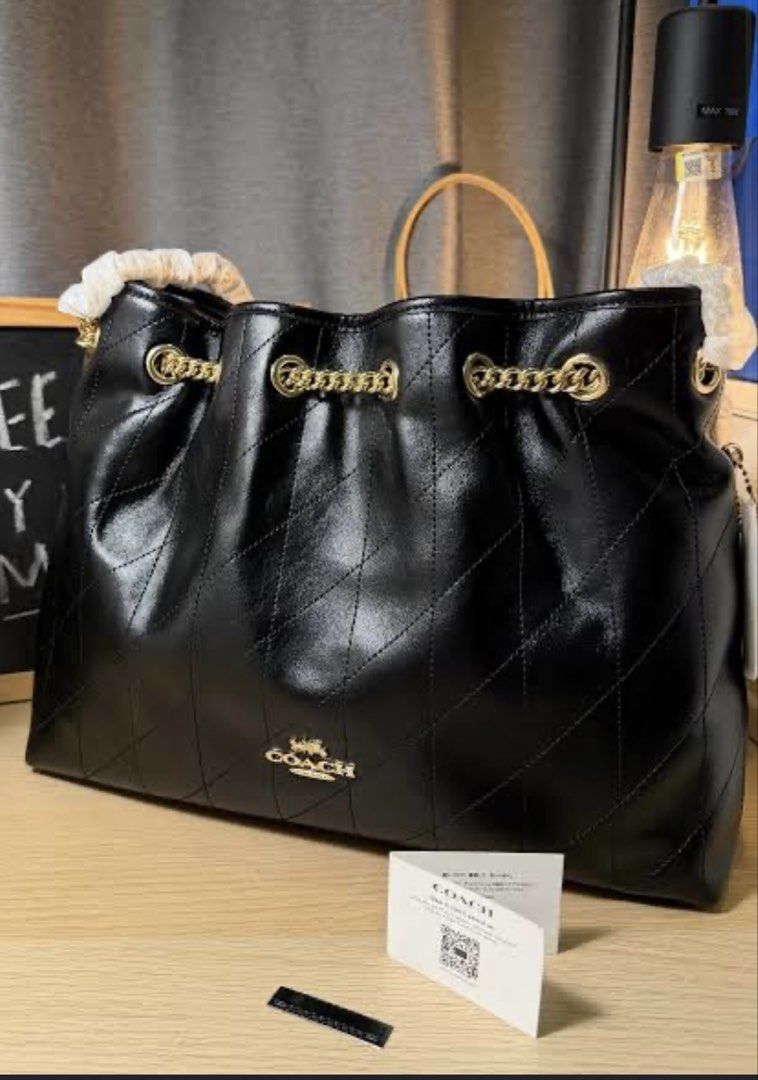 Coach Black Quilted Drawstring Handbag (Category: Luxury Bags & Wallets) located in Manila. Submitted by bravestar.9417e9 (Listing ID 1435454506, Image 1). Description: Black Coach handbag with a quilted design. Features gold-tone chain detailing and a drawstring closure. Includes a Coach tag. The bag has a spacious interior and a classic design. Perfect for everyday use or special occasions. A stylish and versatile accessory..