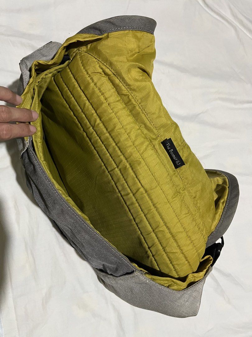 Crumpler The Boomer Messenger Bag (Category: Laptop Bags & Sleeves) located in Pasay City. Submitted by akosilau (Listing ID 1435458847, Image 2). Description: - Gray Crumpler messenger bag - Black adjustable strap - Secure flap closure - Bright yellow, padded interior - Black front patch - Crumpler logo detail - Designed for carrying various items.