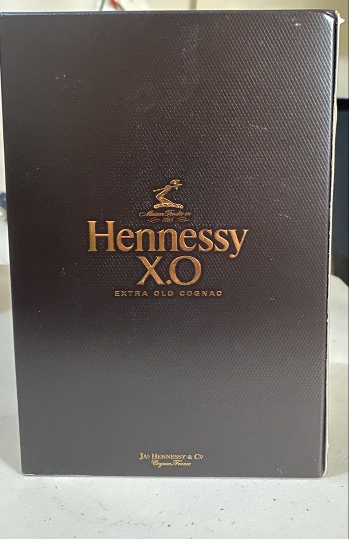 Hennessy X.O Extra Old Cognac (Category: Beverages) located in Quezon City. Submitted by bonth (Listing ID 1435399172, Image 2). Description: - Hennessy X.O Extra Old Cognac - 70cl bottle - 40% Alcohol by Volume (ABV) - Includes original box - Box features Hennessy logo and "Extra Old Cognac" text - Produced by Jas Hennessy & Co, Cognac, France - Box design includes a portrait of a man in a red coat.