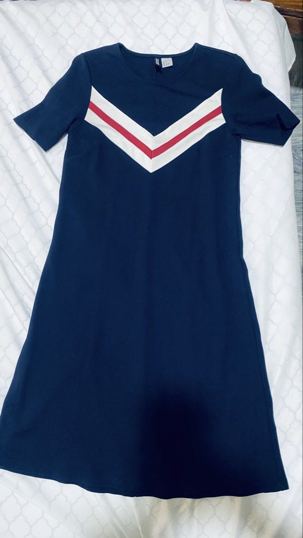 H&M Divided Dress (Category: Dresses) located in Quezon City. Submitted by smithram (Listing ID 1435406495, Image 1). Description: Navy blue dress from H&M Divided. Features a V-neckline with a white and red stripe design on the front. It has short sleeves and a knee-length cut. The dress is size EUR 34, US 2, CA 2, and MX 2. The dress has a simple, classic design suitable for various occasions..