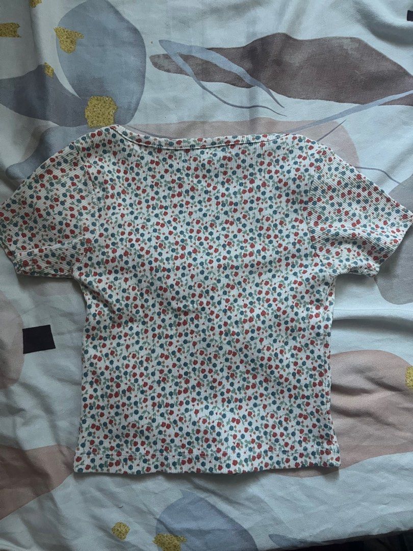 H&M Floral Button-Up Top - Size M (Category: Blouses) located in Paranaque City. Submitted by rieclutter (Listing ID 1435410066, Image 3). Description: - H&M floral top - Size: M - Features: - Button-up front - Scoop neckline - Short sleeves - Style: Cropped - Fabric: Ribbed - Color: White, red, and blue floral print.