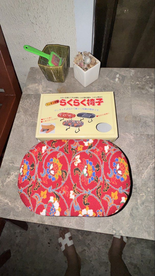 Japanese Folding Stool (Category: Chairs) located in Santa Cruz. Submitted by maqui15 (Listing ID 1435359252, Image 1). Description: - Japanese folding stool - Features a vibrant red floral pattern - Sturdy metal frame with black handles - Brand new in original packaging - Includes decorative fabric cover - Compact and foldable for easy storage.