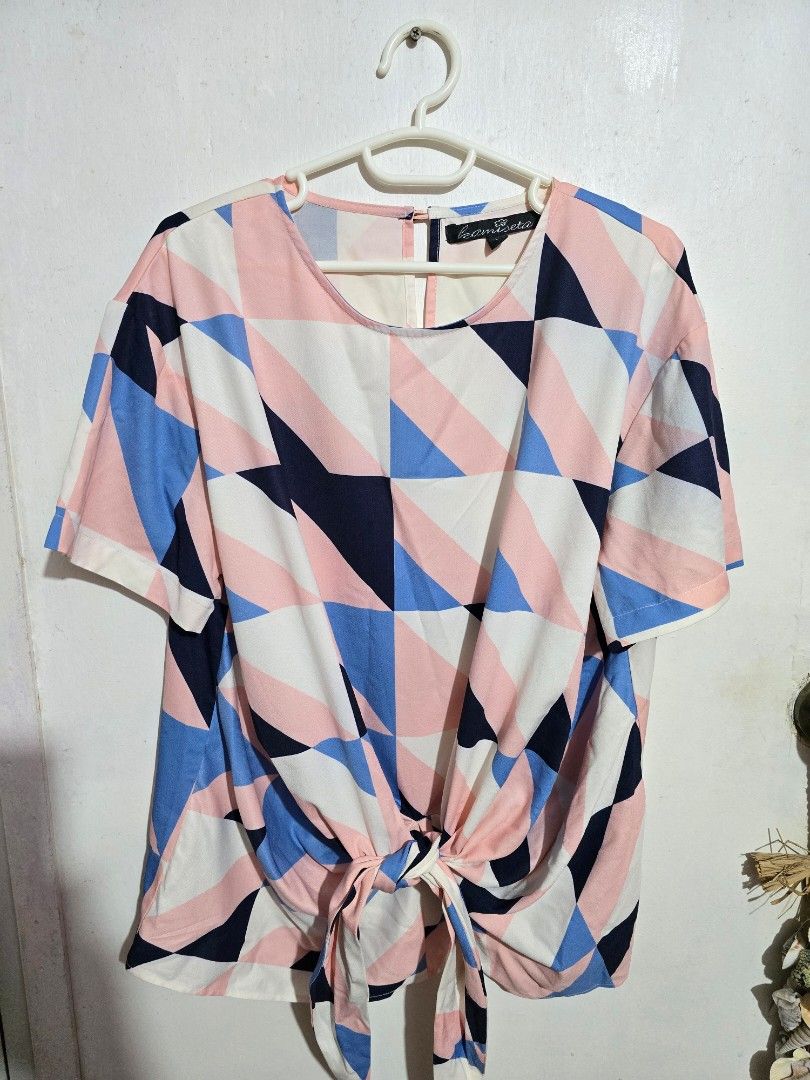 Kamiseta Top L (Category: Blouses) located in Manila. Submitted by hellomrys (Listing ID 1435387899, Image 1). Description: - Kamiseta Top (Size L) - Features a vibrant geometric pattern. - Color pattern: Pink, Blue, and White - Issue: Little fade on button.