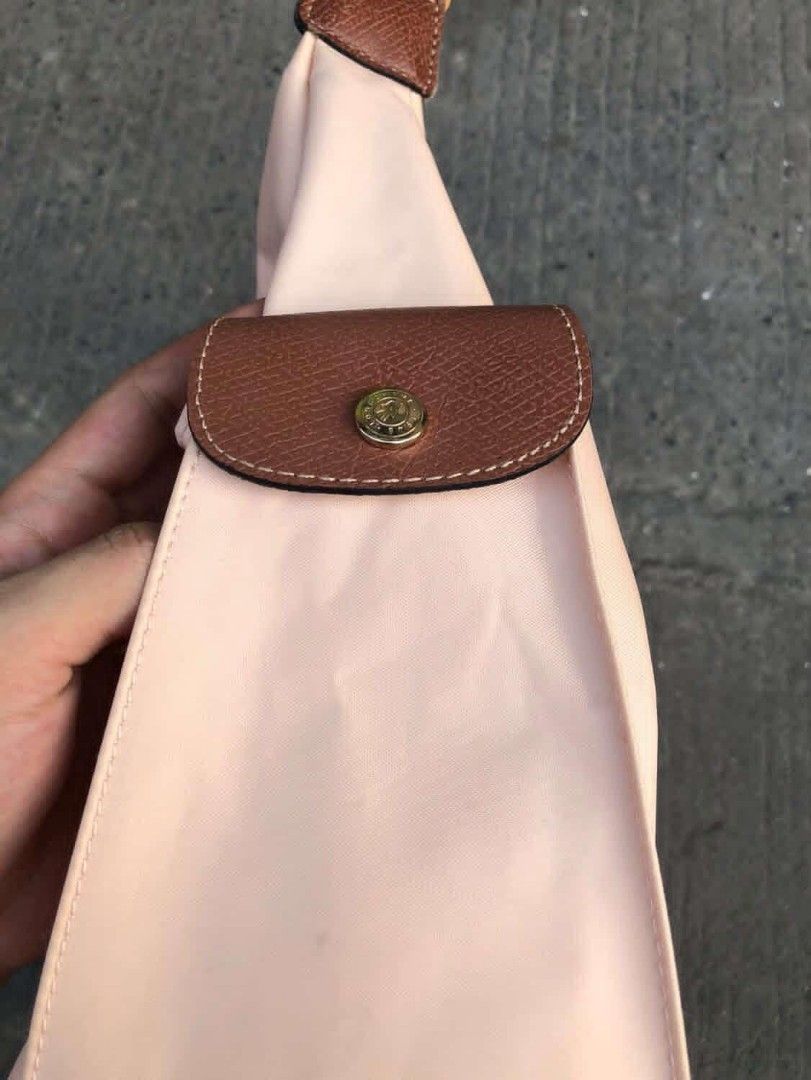 Longchamp hobo shoulder bag (Category: Luxury Bags & Wallets) located in Manila. Submitted by kuyanyo (Listing ID 1435435392, Image 3). Description: - Authentic Longchamp shoulder bag - Light pink nylon body - Brown leather strap and accents - Single main compartment - Small side pocket - Leather flap closure with gold-tone button - Iconic Longchamp logo DM IF INTIRESTED EXCELLENT CONDITION NEEDWASH.