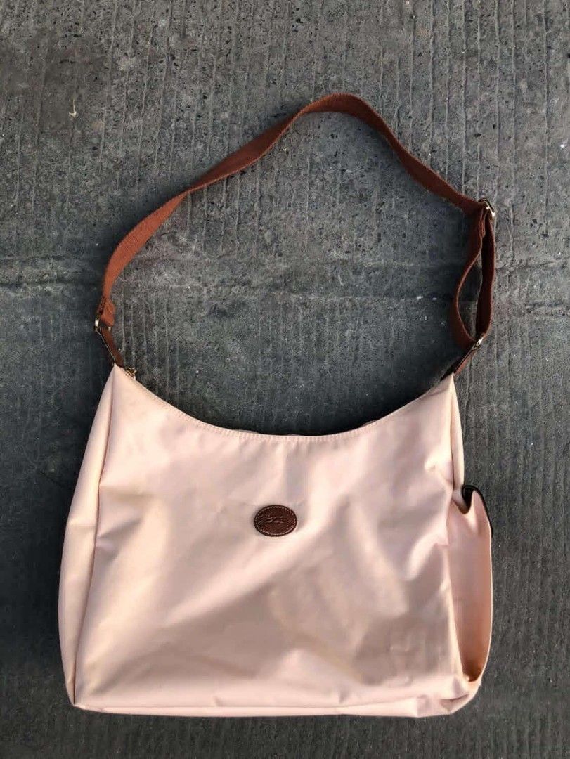 Longchamp hobo shoulder bag (Category: Luxury Bags & Wallets) located in Manila. Submitted by kuyanyo (Listing ID 1435435392, Image 1). Description: - Authentic Longchamp shoulder bag - Light pink nylon body - Brown leather strap and accents - Single main compartment - Small side pocket - Leather flap closure with gold-tone button - Iconic Longchamp logo DM IF INTIRESTED EXCELLENT CONDITION NEEDWASH.