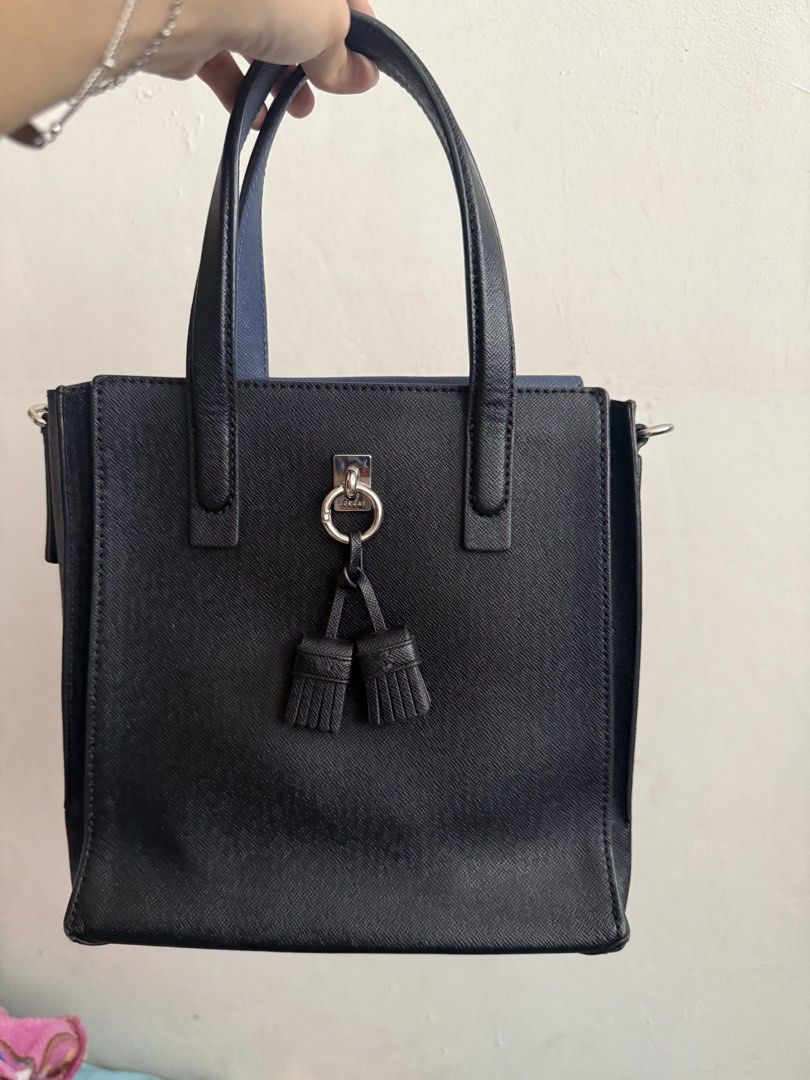 Lovcat Black Handbag with Tassels (Category: Luxury Bags & Wallets) located in Marikina City. Submitted by ayessadimagiba_753 (Listing ID 1435340536, Image 1). Description: - Black Lovcat handbag - Detachable strap included - Features top handle and tassel detail - Magnetic closure - Brown interior lining with small pocket - Comes with a patterned strap - Small Lovcat label inside.