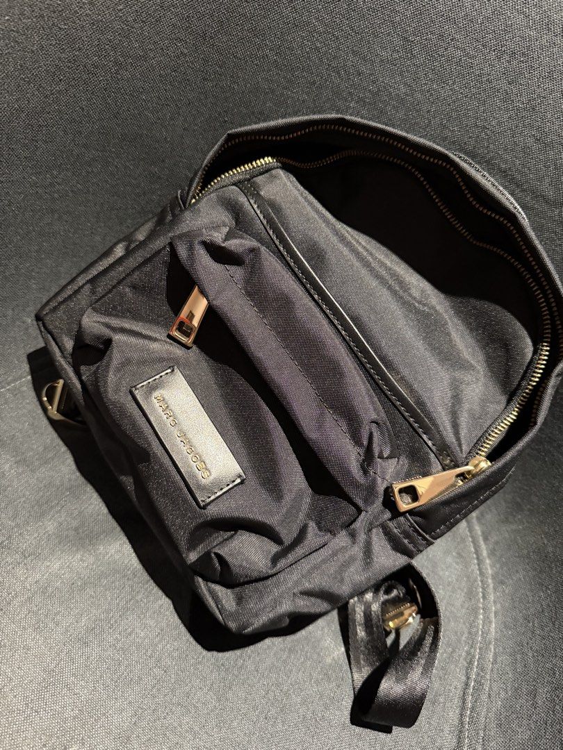 Marc Jacobs Black back pack (Category: Luxury Bags & Wallets) located in Manila. Submitted by khrizziebee (Listing ID 1435470113, Image 1). Description: Black sling bag from Marc Jacobs. Features a zippered main compartment and an adjustable strap. The bag has a small front pocket and a gold-toned zipper. The Marc Jacobs logo is visible on the front..