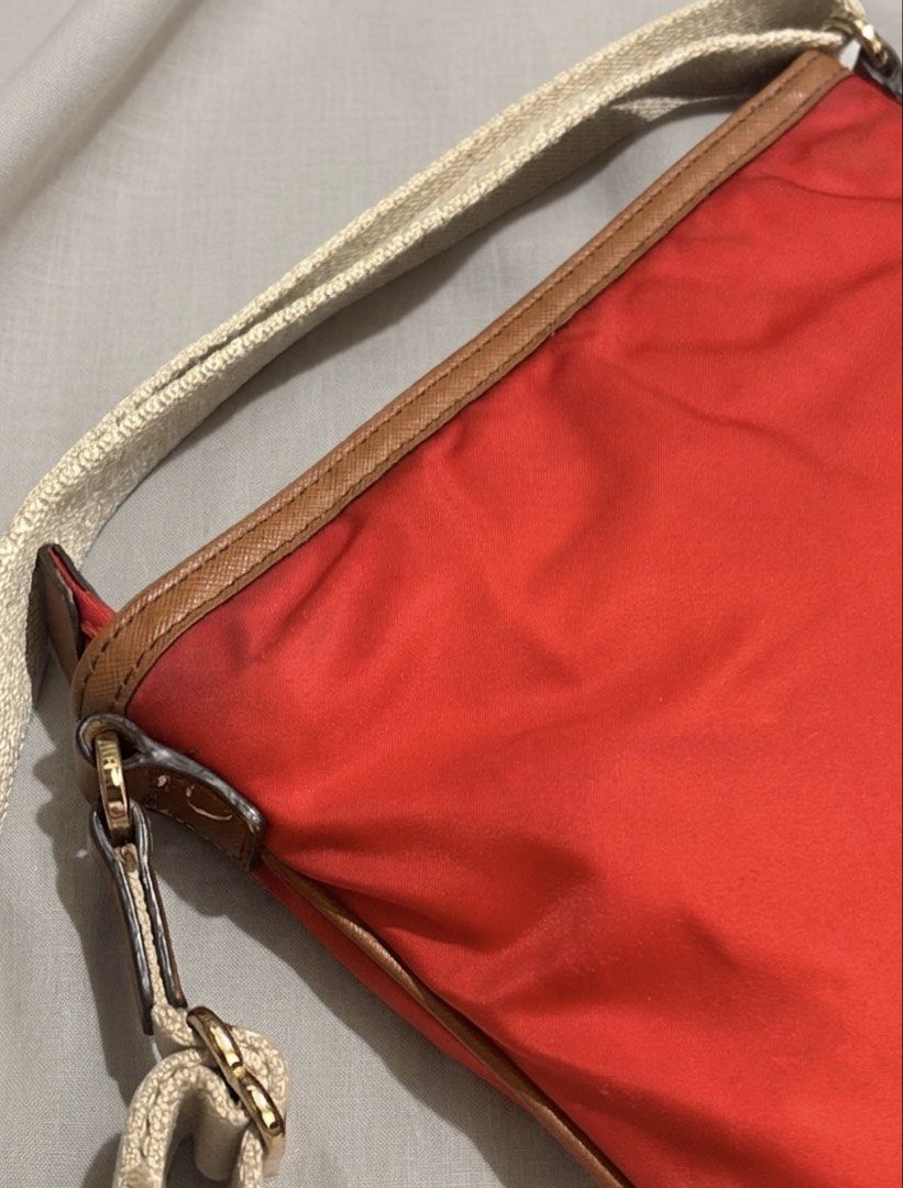 Michael Kors Nylon Crossbody Bag (Category: Cross-body Bags) located in Aparri. Submitted by lpenny (Listing ID 1435509888, Image 3). Description: - Michael Kors crossbody bag - Vibrant red nylon exterior - Brown leather trim - Gold-tone zipper - Signature MK logo - Adjustable strap - Red interior lining - Front zippered pocket - Main compartment (Needs cleaning).