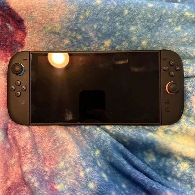 Nintendo Switch Console (Category: Nintendo) located in New Bataan. Submitted by newgem.15937b (Listing ID 1435341343, Image 3). Description: - Nintendo Switch console - Includes console and controllers - Features black controllers with blue and orange joysticks.