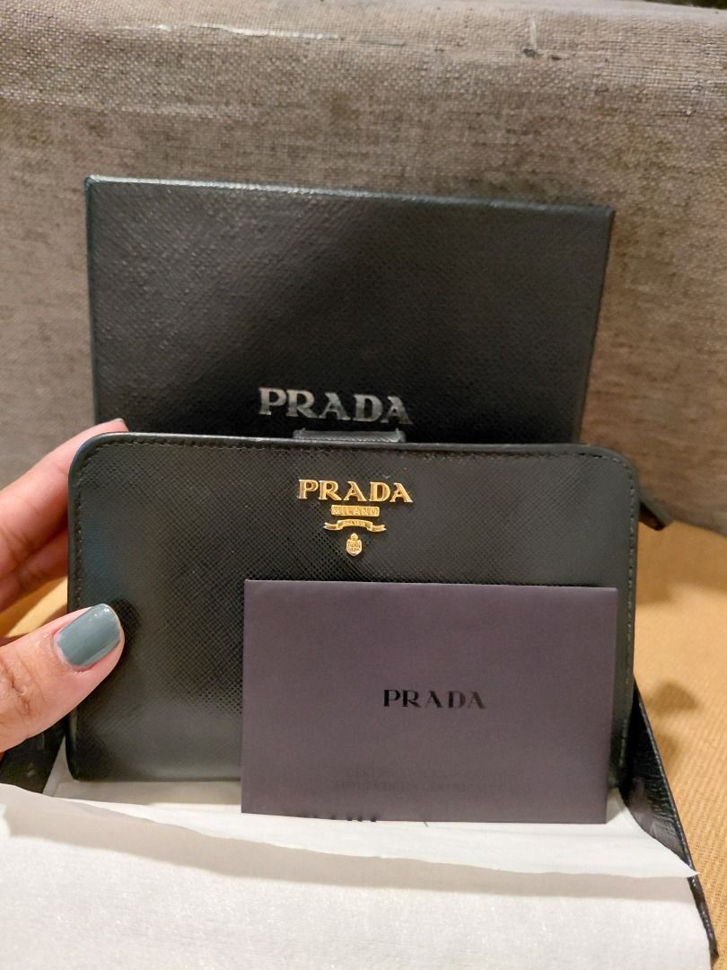 Prada Saffiano Leather Zip Wallet (Category: Luxury Bags & Wallets) located in Makati City. Submitted by jisla (Listing ID 1435510133, Image 2). Description: - Authentic Prada wallet - Black Saffiano leather - Gold-tone hardware - Prada logo - Zip closure - Includes box, authenticity card, and dust bag - Multiple compartments - Stylish and functional.