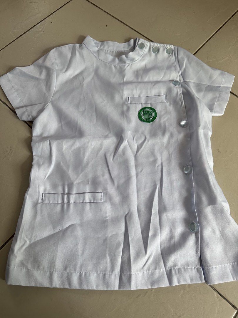 White Medical Uniform Top (Category: Blouses) located in Manila. Submitted by rachael_23 (Listing ID 1435348632, Image 1). Description: - White medical uniform top - Short sleeves - Mandarin collar - Button-up closure - Chest pocket - Small emblem - Decorative back panel - Ideal for medical professionals and students.