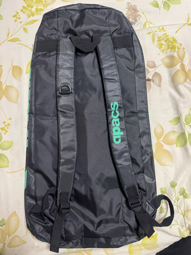Apacs Badminton Racket Bag (Category: Racket and Ball Sports) located in Valenzuela. Submitted by fairythrift (Listing ID 1437118578, Image 3). Description: - Apacs badminton racket bag - Spacious main compartment with orange interior - Front pocket for extra storage - Top compartment for additional storage - Stylish black exterior with teal accents - Features the Apacs logo - Comfortable, adjustable shoulder straps.