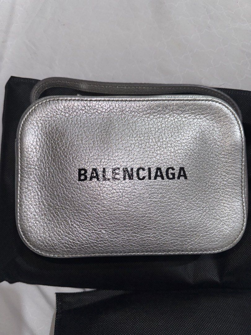 Balenciaga Metallic Silver Camera Bag (Category: Luxury Bags & Wallets) located in Quezon City. Submitted by jdmc16 (Listing ID 1437145586, Image 1). Description: - Metallic silver Balenciaga handbag - Includes a wrist strap - Detachable shoulder strap included - Features the Balenciaga logo - Comes with a dust bag - Made of leather with a textured finish.