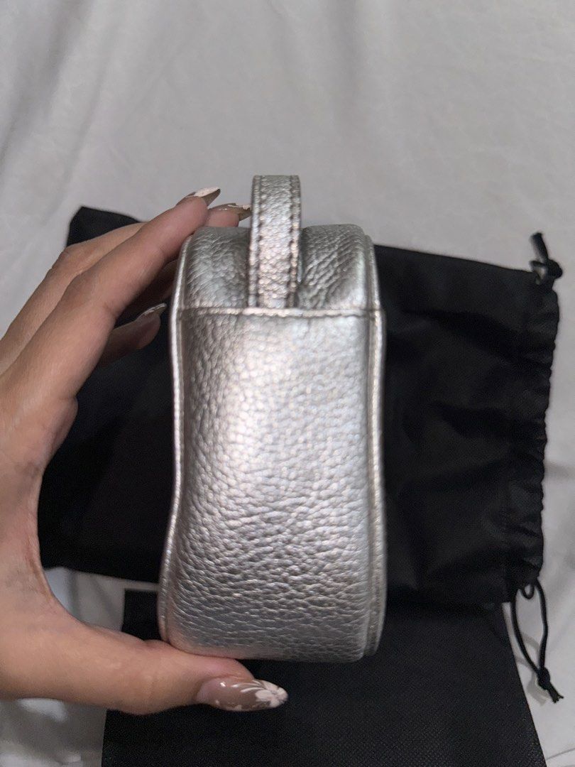 Balenciaga Metallic Silver Camera Bag (Category: Luxury Bags & Wallets) located in Quezon City. Submitted by jdmc16 (Listing ID 1437145586, Image 2). Description: - Metallic silver Balenciaga handbag - Includes a wrist strap - Detachable shoulder strap included - Features the Balenciaga logo - Comes with a dust bag - Made of leather with a textured finish.