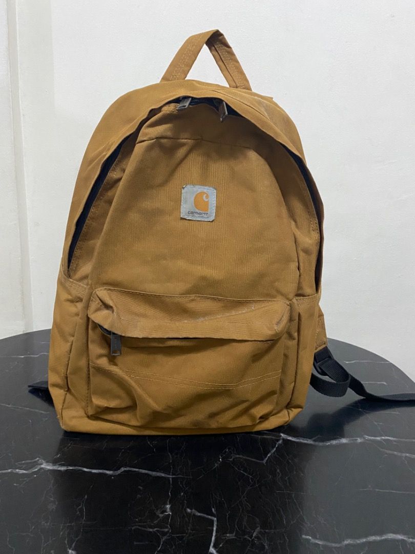 Carhartt Backpack (Category: Backpacks) located in Manila. Submitted by haveago0dthrift (Listing ID 1437036235, Image 1). Description: - Carhartt backpack in tan. - Front pocket with zipper closure. - Padded shoulder straps. - Quilted back design. - Minor stains on front pocket. - Some wear and tear on corners..