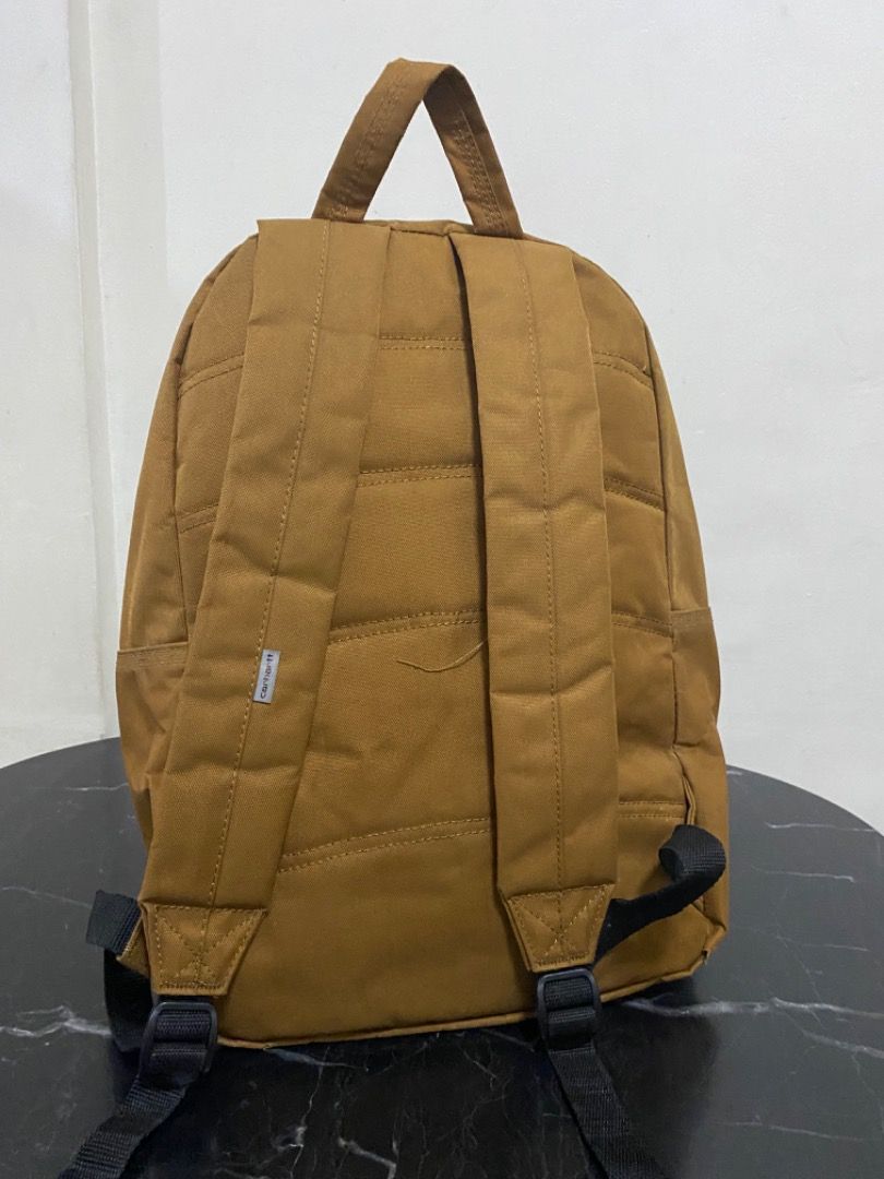 Carhartt Backpack (Category: Backpacks) located in Manila. Submitted by haveago0dthrift (Listing ID 1437036235, Image 2). Description: - Carhartt backpack in tan. - Front pocket with zipper closure. - Padded shoulder straps. - Quilted back design. - Minor stains on front pocket. - Some wear and tear on corners..