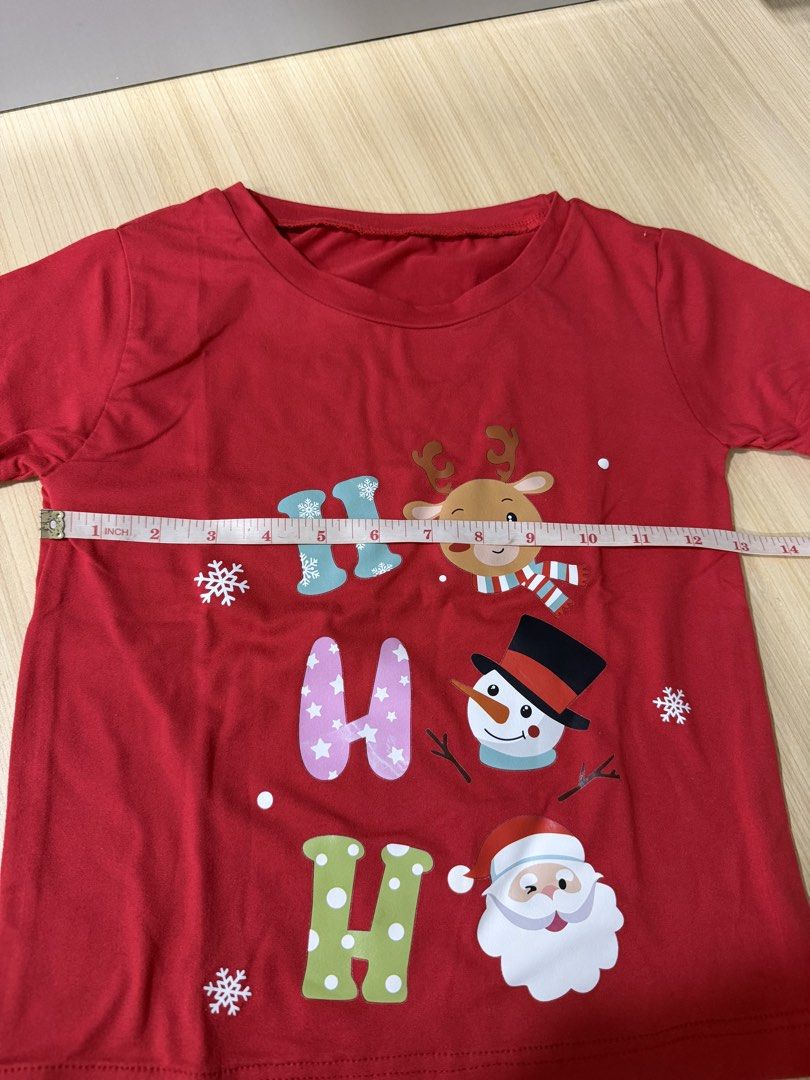 Christmas Red T-shirt (Category: Babies & Kids Fashion) located in Mandaluyong City. Submitted by jpc0708 (Listing ID 1437135573, Image 3). Description: - Red Christmas t-shirt - Features "HO HO HO" design with reindeer, snowman, and Santa Claus - Short sleeves - Round neckline - Measurements: Approximately 17 inches length x 13 inches width - Plain red back.