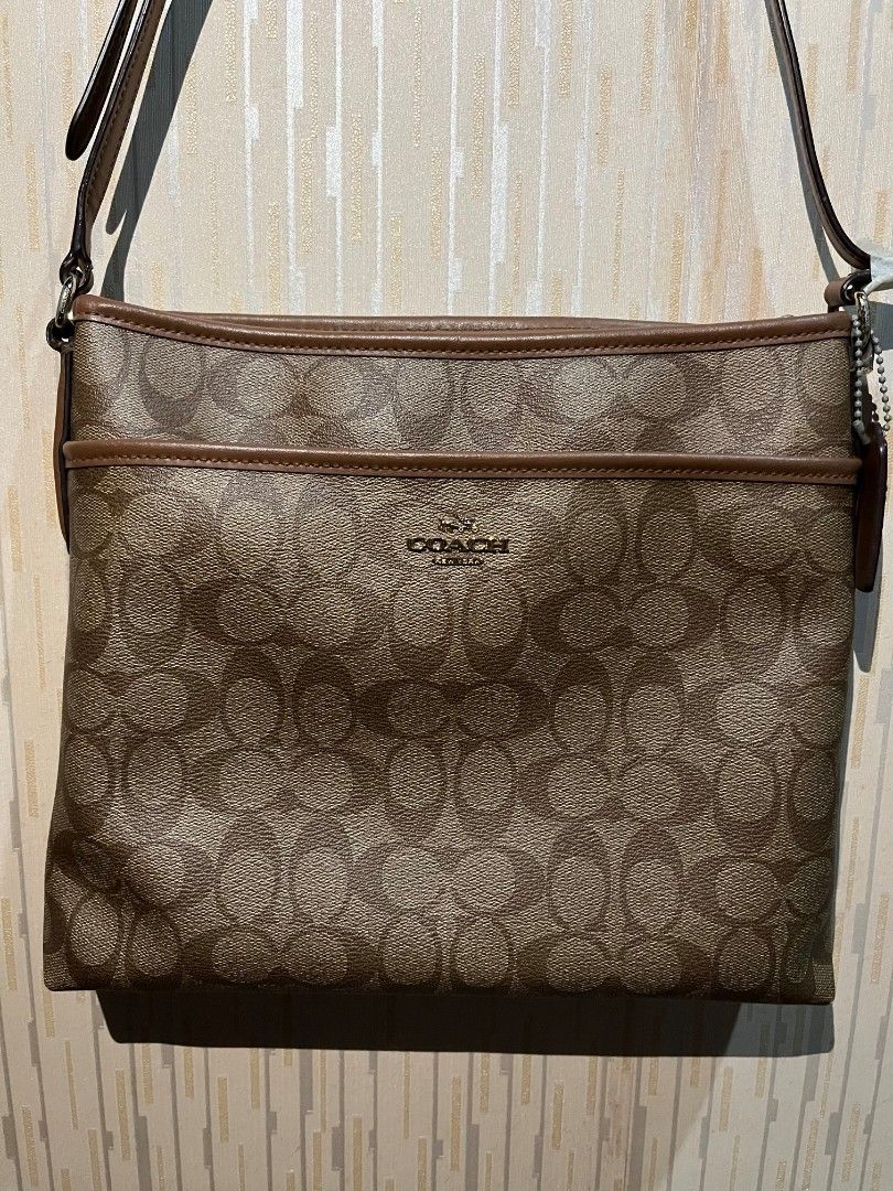 Coach Signature Crossbody Bag (Category: Luxury Bags & Wallets) located in Makati City. Submitted by neenee_ (Listing ID 1437018535, Image 1). Description: Original Coach Signature File Crossbody Bag Outside bag looks very good - barely doesnt have any flaws. The hardware needs cleaning. Strap has tape because i was planning on having it cut, but no signs of cracking yet (as shown in picture) Issue: Creed Overall, bag is still in good condition e