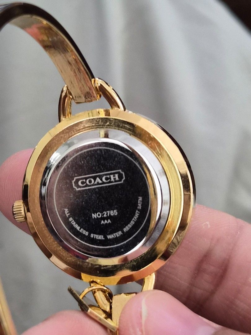 Coach Women's Bangle Watch (Category: Looking For) located in Mandaue City. Submitted by chuchi152615 (Listing ID 1437040625, Image 3). Description: - Coach women's watch - stainless / water resistant - Gold-tone bangle strap - White dial with gold-tone hands and markers - Colorful circle pattern on the dial - Coach logo and '2765' on the back - Includes Coach tag.