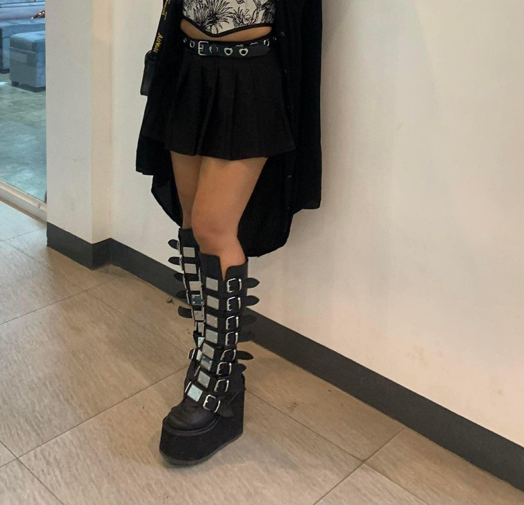 Demonia Swing-815 Black Vegan Boots (Category: Boots) located in Cebu City. Submitted by books4less (Listing ID 1437039679, Image 3). Description: - Demonia Swing-815 boots - Black vegan leather - Knee-high design - Chunky platform sole - Multiple straps with silver buckles - Stylish and edgy.