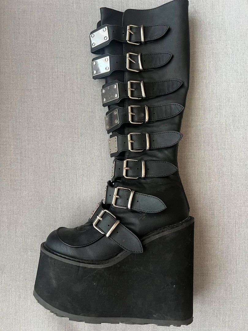 Demonia Swing-815 Black Vegan Boots (Category: Boots) located in Cebu City. Submitted by books4less (Listing ID 1437039679, Image 1). Description: - Demonia Swing-815 boots - Black vegan leather - Knee-high design - Chunky platform sole - Multiple straps with silver buckles - Stylish and edgy.