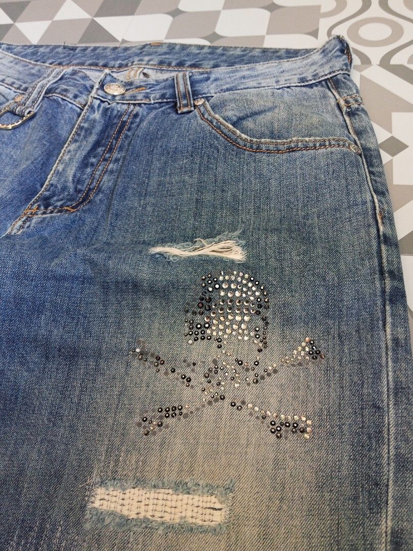 Distressed Jeans with Skull Detail (Category: Jeans) located in Manila. Submitted by rahzzelula73279 (Listing ID 1437194893, Image 3). Description: - Distressed jeans with skull and crossbones rhinestone design. - Classic five-pocket design. - Button closure with decorative ring. - Medium wash. - Relaxed fit. - Leather patch on back pockets. SIZE 32 BIDS LNG MINIMAL ISSUE .