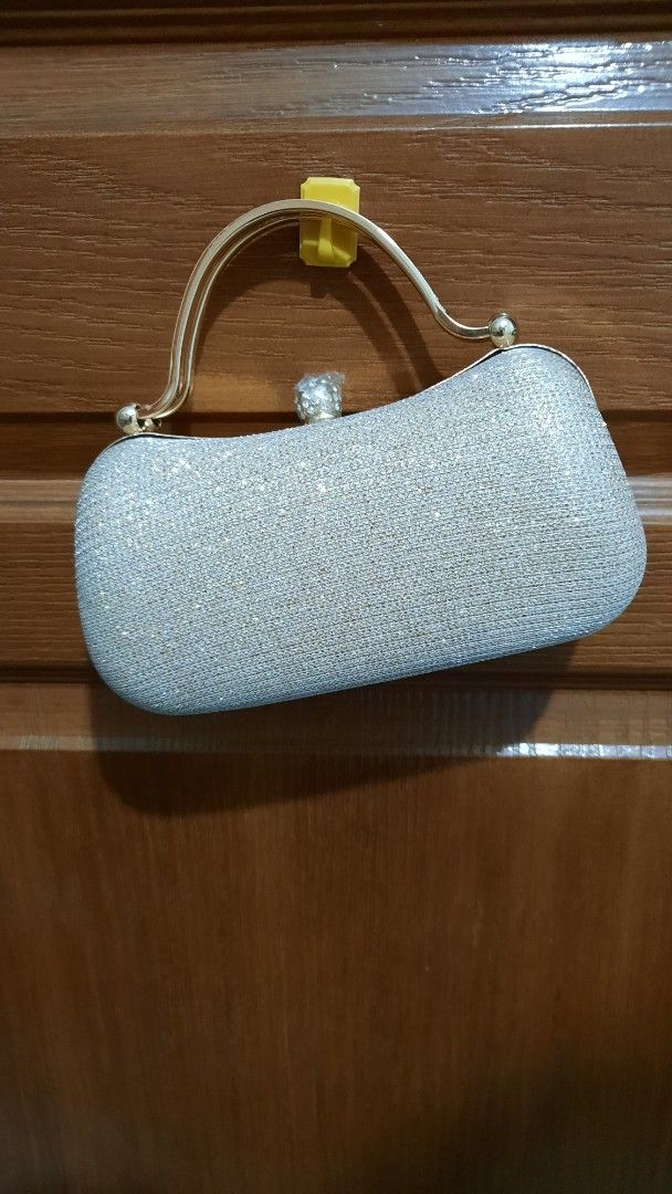 Elegant Clutch Bag with Chain Strap (Category: Clutches) located in Pasig City. Submitted by decluterringformentalhealth (Listing ID 1437198660, Image 1). Description: - Champagne-gold shimmering exterior - Gold-toned handle - Black fabric lining - Secure clasp closure - Never been used - Ideal for special events.