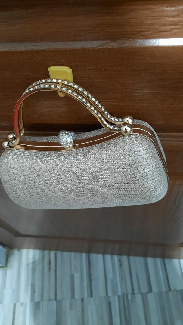 Elegant Clutch Bag with Chain Strap (Category: Clutches) located in Pasig City. Submitted by decluterringformentalhealth (Listing ID 1437198660, Image 2). Description: - Champagne-gold shimmering exterior - Gold-toned handle - Black fabric lining - Secure clasp closure - Never been used - Ideal for special events.