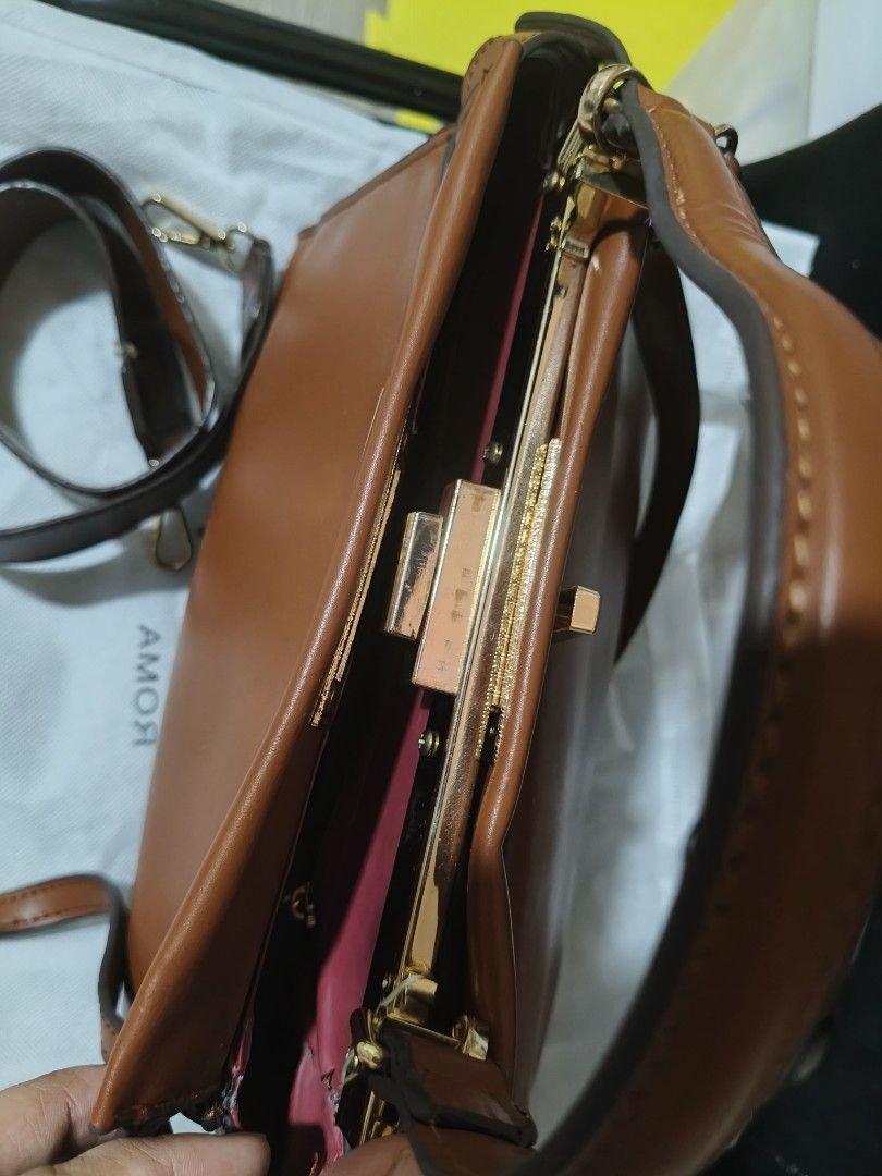 Fendi Brown Leather Handbag (Category: Luxury Bags & Wallets) located in Manila. Submitted by 8chay (Listing ID 1437018145, Image 3). Description: - Brown leather Fendi handbag - Top handle and detachable shoulder strap - Gold-tone clasp and hardware - Pink fabric interior lining - Includes dust bag - Shoulder strap with Fendi logo.