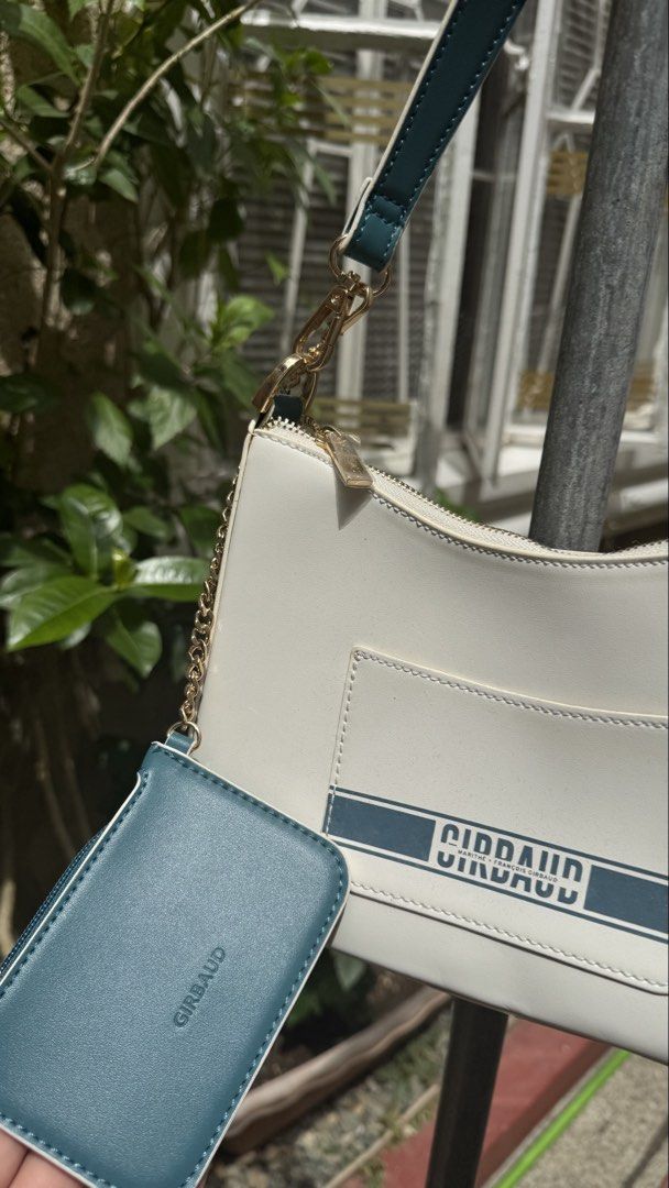 Girbaud Shoulder Bag with Card Holder (Category: Luxury Bags & Wallets) located in Manila. Submitted by lovejas.mnl (Listing ID 1437032390, Image 3). Description: - Girbaud shoulder bag - White body with teal accents - Gold chain detail - Zipper closure - Includes detachable card holder - Ideal for everyday use.