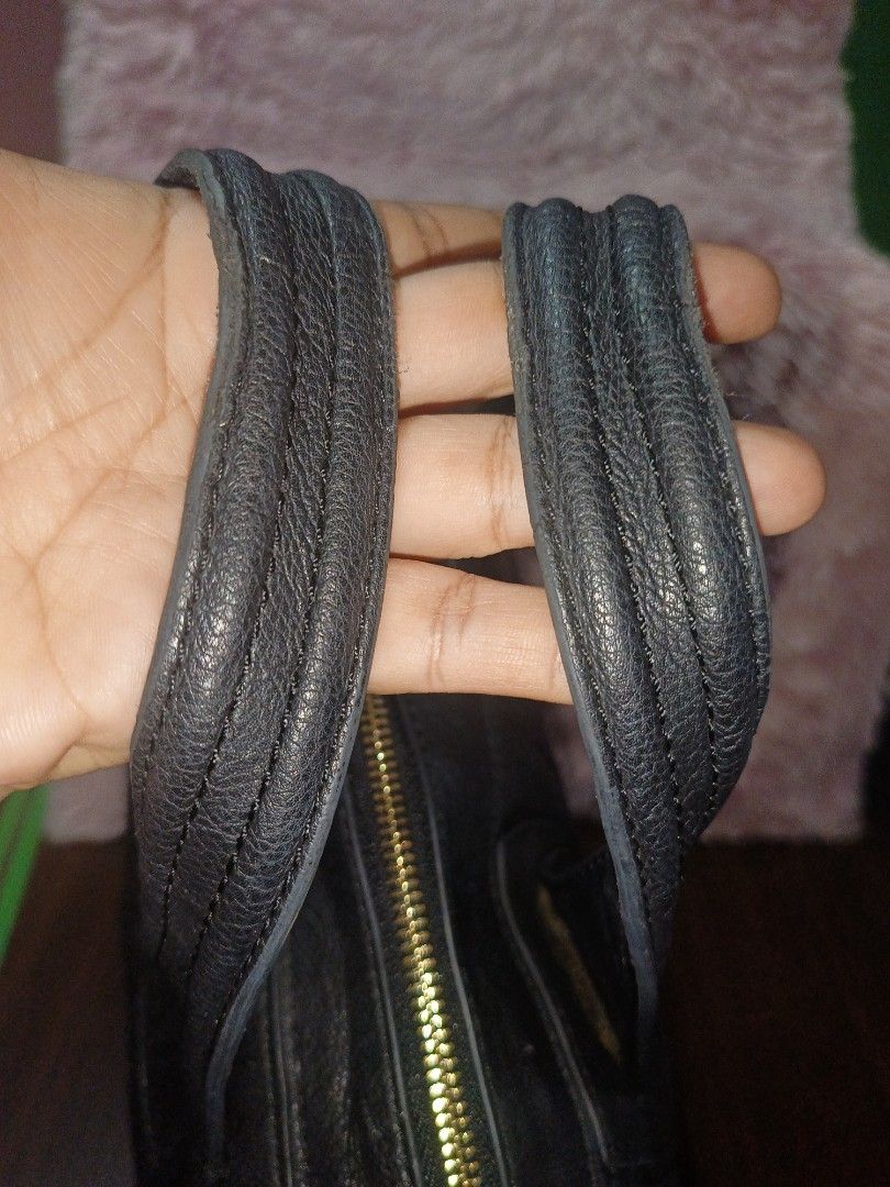 Givenchy Black Leather Handbag (Category: Luxury Bags & Wallets) located in Rizal. Submitted by judithtillo19 (Listing ID 1437143392, Image 3). Description: - Givenchy black leather handbag - Top handle design - Embossed logo detail - Gold-toned zipper closure - Made in Italy - Textured leather finish - Spacious interior NOTE: PRELOVED BUT IN GOOD CONDITION NO SLING INCLUDED CLEAN ( NEW SPA) 12"X16"X6".